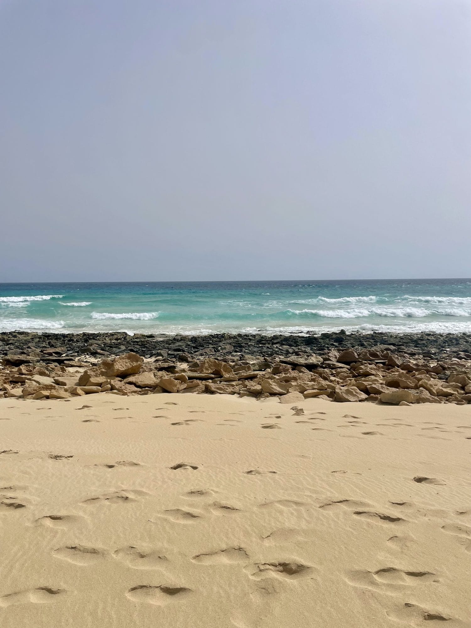 Sand, rocks and sea by the dunes