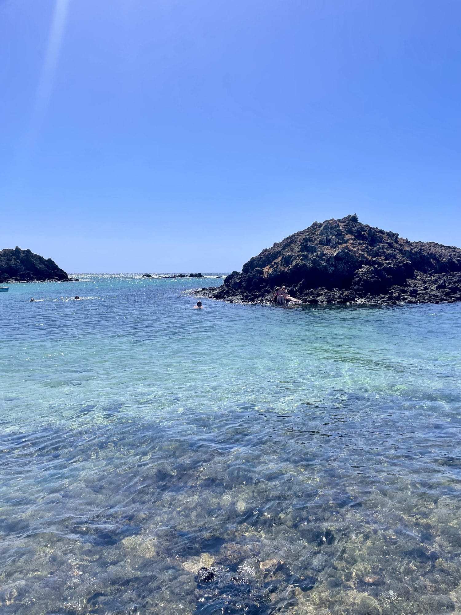 Clear blue water and a dark volcanic rock on Islote de Lobos